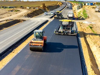 Straßenbauarbeiten mit Asphaltiermaschine und Baupersonal – symbolisch für die digitale Baustellenabwicklung mit Pro-Bau/S® AddOne im Straßenbau.