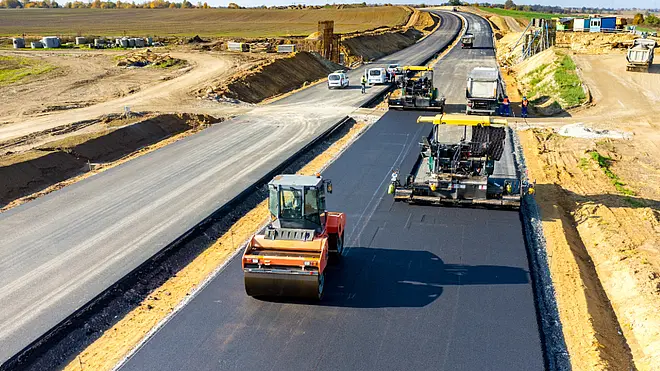 Straßenbauarbeiten mit Asphaltiermaschine und Baupersonal – symbolisch für die digitale Baustellenabwicklung mit Pro-Bau/S® AddOne im Straßenbau.